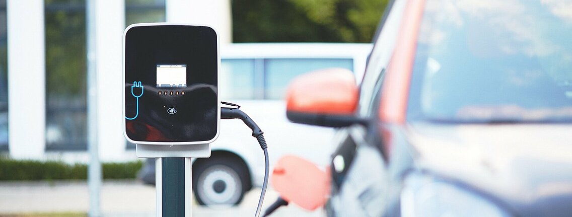 An electric vehicle at a charging station with a plugin.