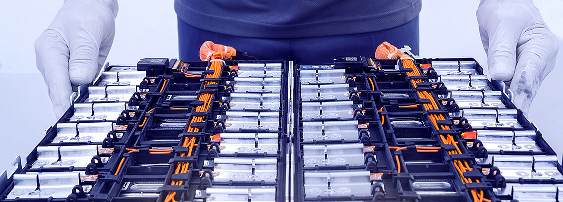 Battery pack with two hands working on it. 