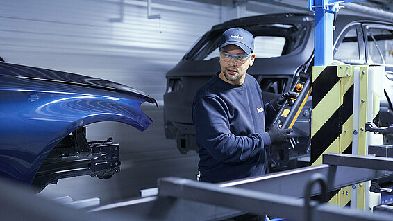 Ein Leadec-Mitarbeiter bei der Fehlersuche am Fördersystem in einer Automobilfabrik.