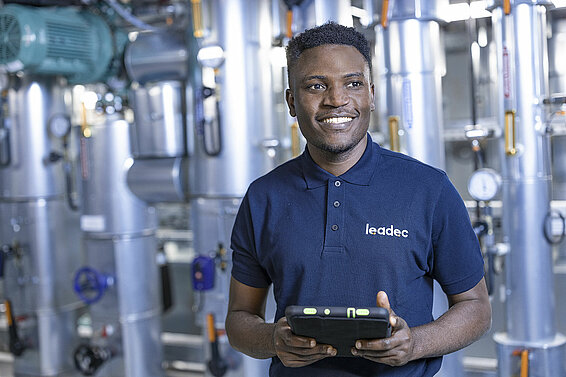 Leadec employee in factory with a tablet. 