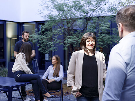 Several Leadec employees having conversations in the outdoor area of the office.