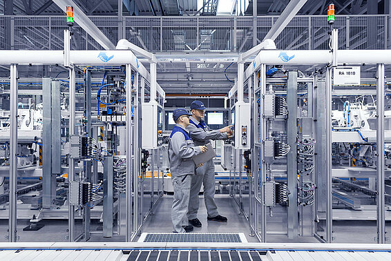 Zwei Leadec-Mitarbeiter überprüfen das Bedienfeld einer Automatikstation.