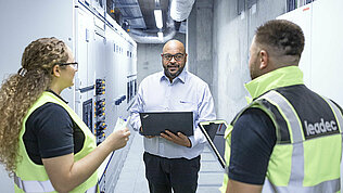 Leadec team talking in a factory corridor.