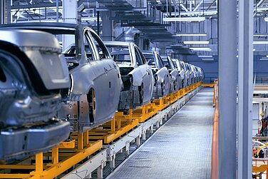 Autokarossen auf einem Förderband in einer Fabrik. 