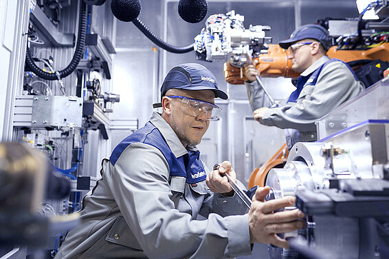 Zwei Leadec-Mitarbeiter bei der Wartung eines Roboters in der Produktion.