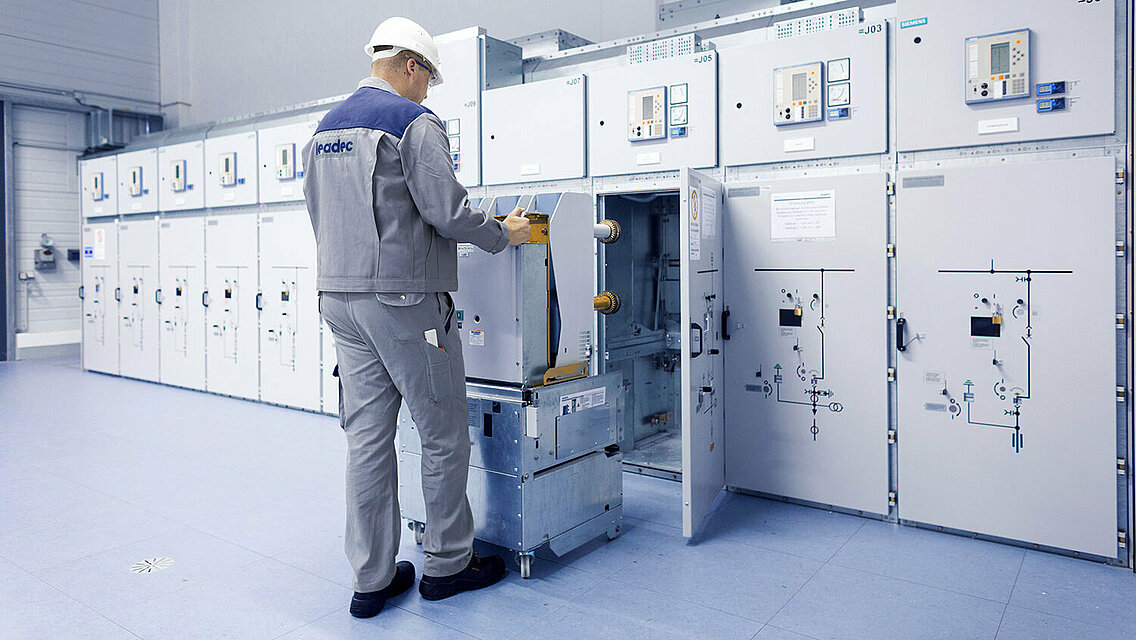 A Leadec employee installing a switchgear in a technical room. 