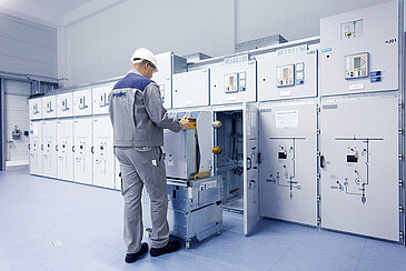 A Leadec employee installing a switchgear in a technical room. 