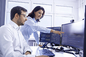Zwei Leadec-Mitarbeitende bei der Planung von Automatisierungslösungen am PC.