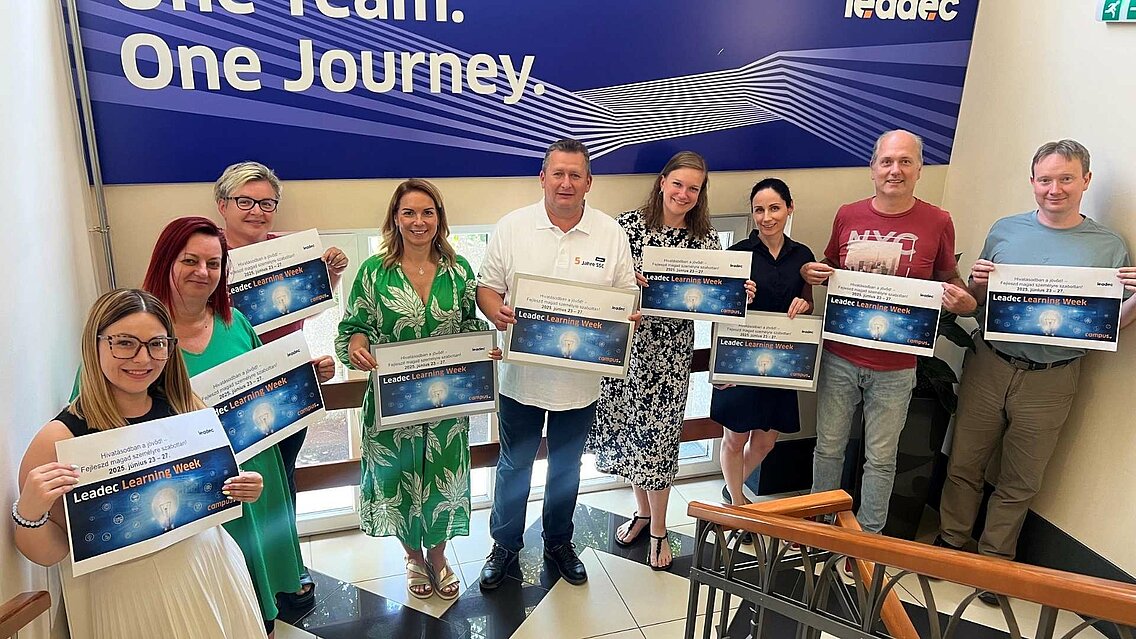 Group of Leadec colleagues holding posters of the Learning Week in their hands. 