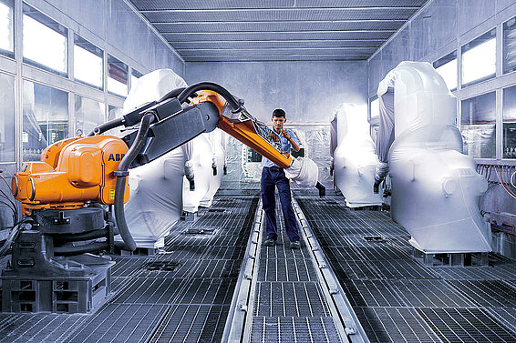 Ein Leadec-Mitarbeiter bei der Wartung eines Roboters in einer Lackieranlage.