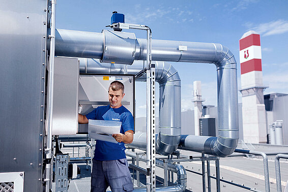 Leadec employee on roof checks external installation of ventilation system. 