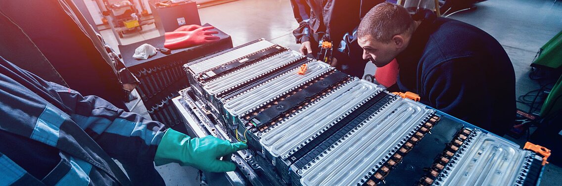Batterie auf Gestell mit zwei Arbeitern, die montieren.