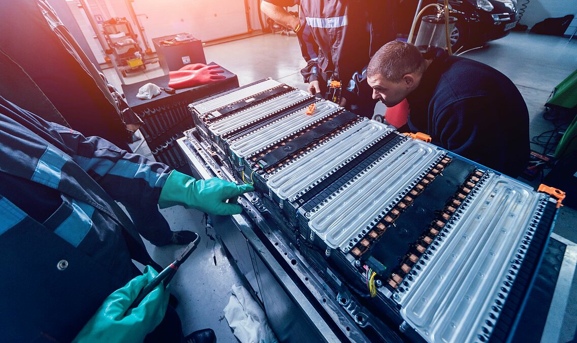 Batterie auf Gestell mit zwei Arbeitern, die montieren.