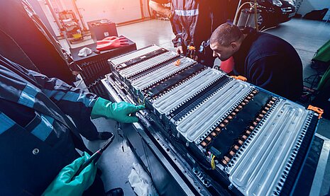Battery on frame with two workers assembling.