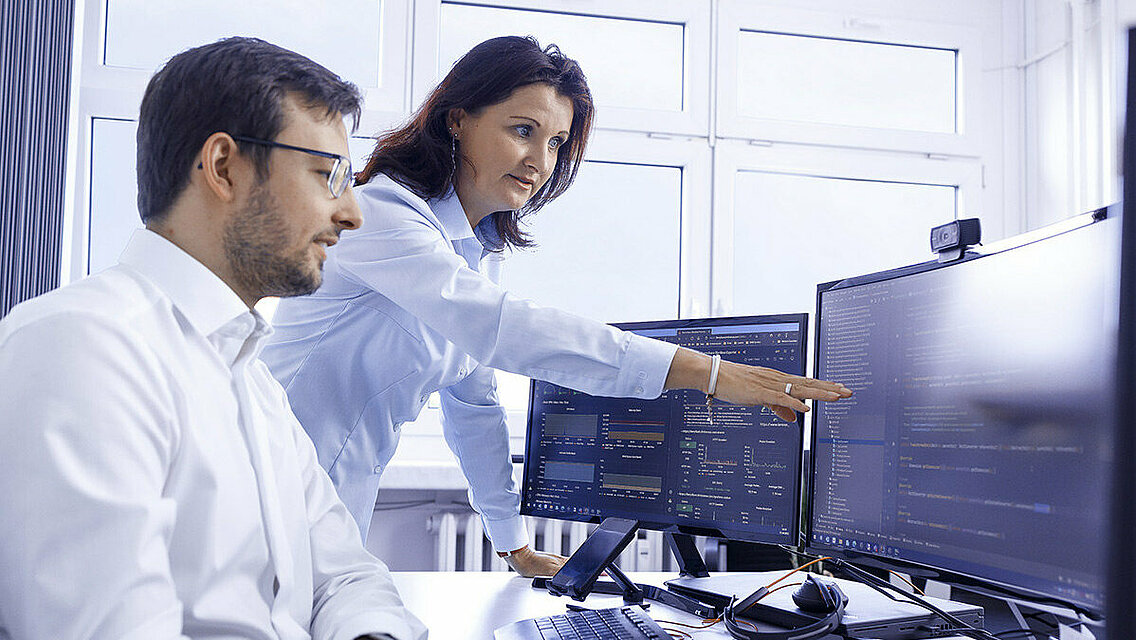 Zwei Leadec-Mitarbeitende bei der Planung von Automatisierungslösungen am PC.