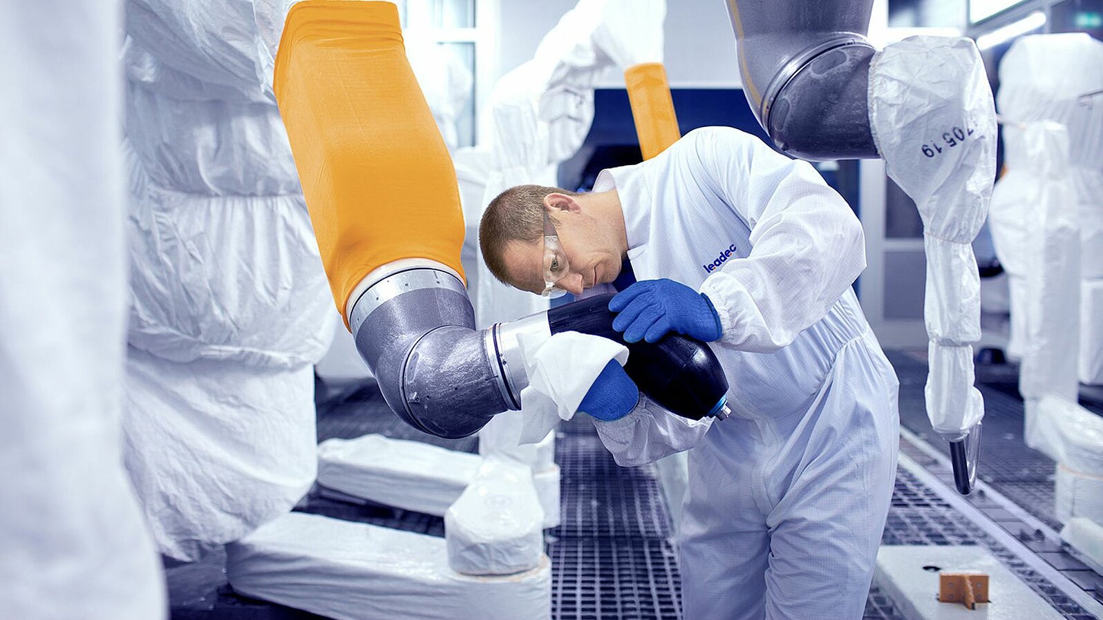 Leadec employee cleaning robot in a paint shop.