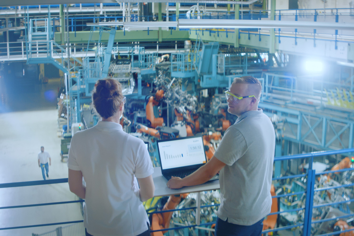 Two people with a laptop in a factory.