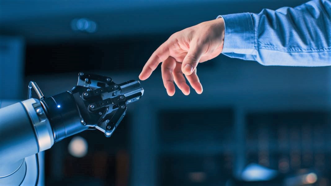 Roboterarm und menschliche Hand treffen sich in der Mitte.