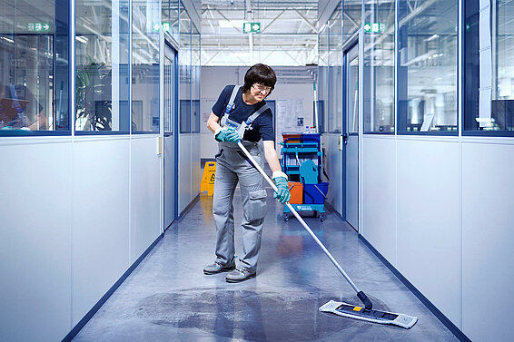 A Leadec employee cleaning the shopfloor.
