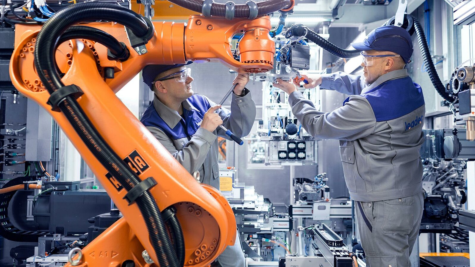 Two Leadec employees maintaining a robot in a production.