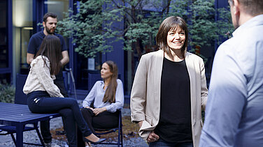 Several Leadec employees having conversations in the outdoor area of the office.