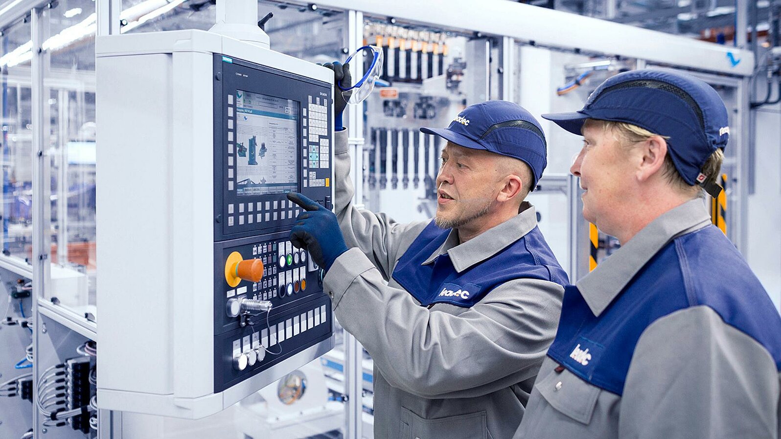 Two Leadec employees checking the display of an automatic station.
