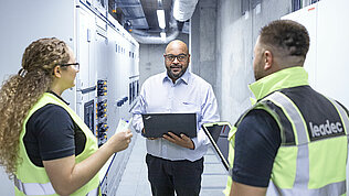 Leadec team talking in a factory corridor.