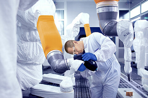 Leadec employee cleaning robot in a paint shop.