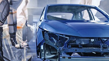 Blue vehicle body in a paint shop.