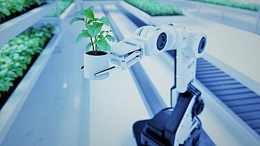 A robot arm on a conveyor belt holds a green plant.