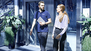 Two Leadec employees coming out of the elevator at the Leadec office in Stuttgart.