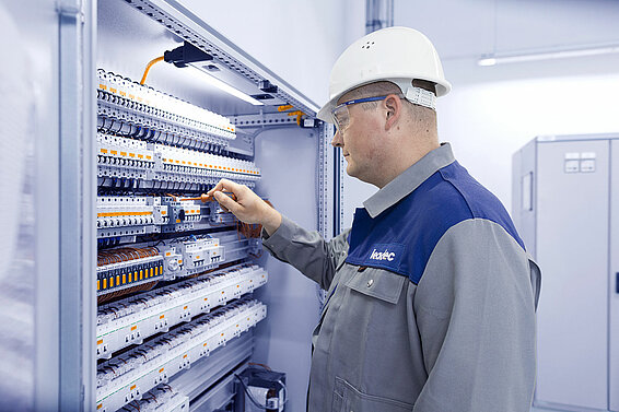 A Leadec employee working at a control cabinet.