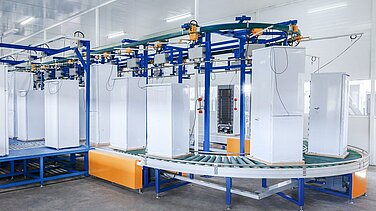 View of a conveyor belt with several refrigerators on it.