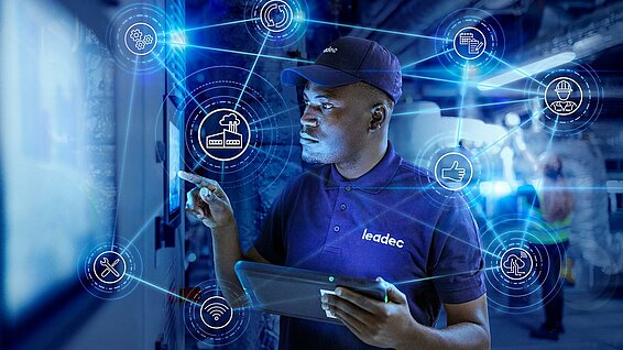 Leadec employee in a factory in front of screen.