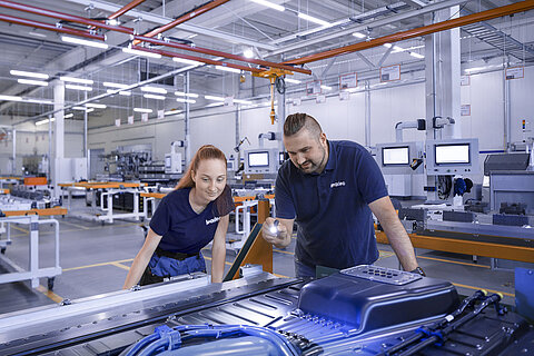 Two Leadec employees checking the battery housing.