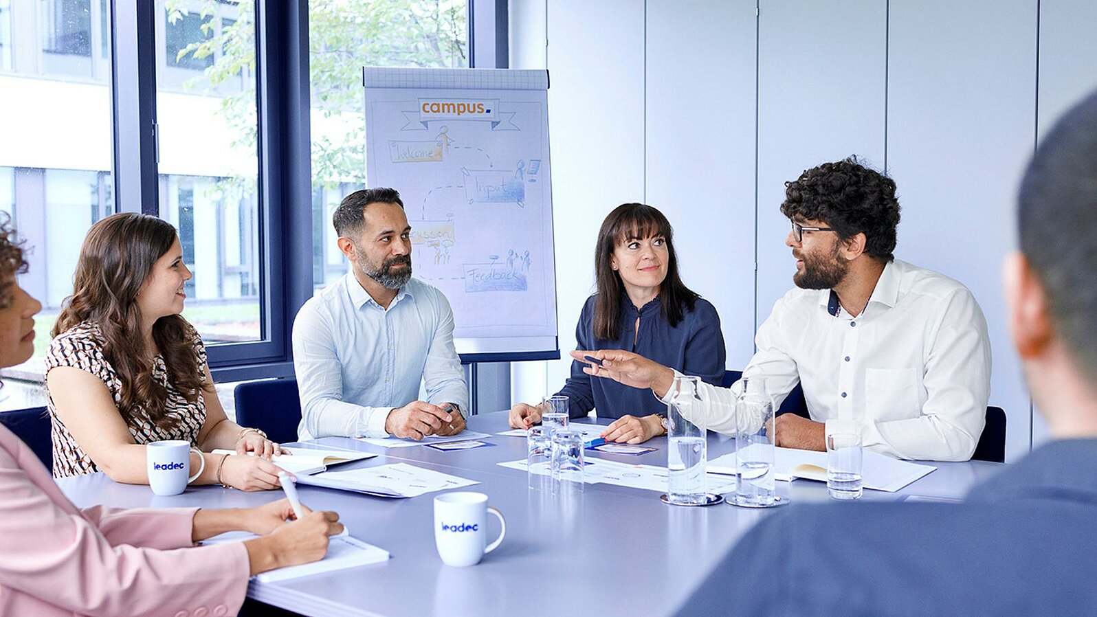 Group of Leadec employees at a meeting in conference room.