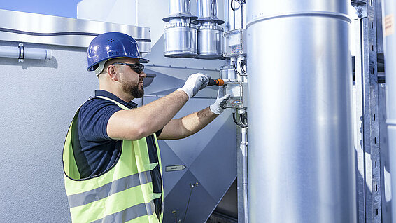 Leadec employee working at ventilation system on a factory roof.